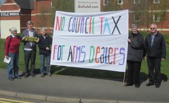 Campaigners holding banner saying "No Council Tax for arms dealers"